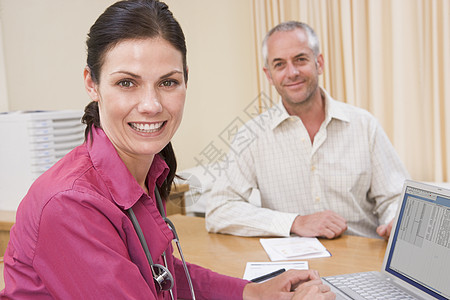 有笔记本电脑的医生 和在医生办公室的男人微笑着疾病中年讨论外科两个人医学咨询博士着装相机图片