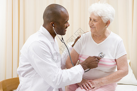 医生在检查室向妇女提供听诊器检查女性男性两个人考试手术大衣胸部退休医师病人图片