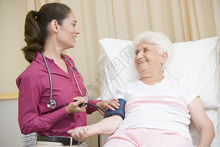 检查女考室妇女血压的医生微笑着微笑疾病病人咨询博士袖口两个人医学外科讨论着装图片