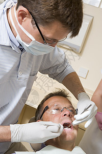 由男主席在考试室担任牙医和助理面具诊所女性手术病人保健牙科口罩卫生三个人图片