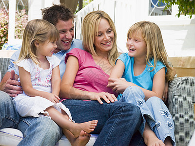 家人坐在院子上微笑家庭孩子四个人母亲女孩甲板后院爸爸女士家长图片