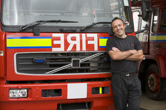 一名消防员站在消防机旁边的肖像男人英雄中年人好榜样服务消防男性水平情况消防队员图片