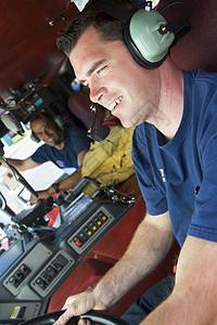 驾驶消防车的消防员好榜样服务电话男人英雄消防队员情况司机耳机成人图片
