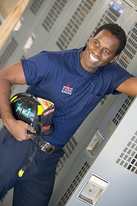 在消防站更衣室对消防员的肖像消防队员男人好榜样中年服务储物柜英雄消防制服头盔图片