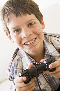年轻男孩拿着电子游戏控制器微笑图片