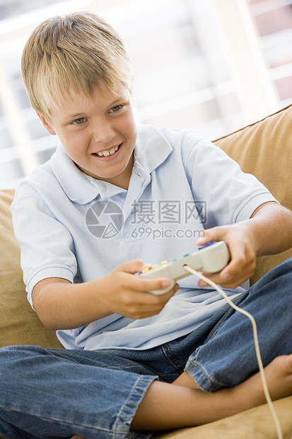 小男孩在客厅 与视频游戏控制器微笑图片
