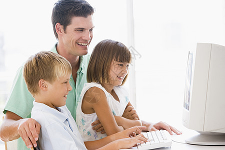 男人和两个小孩在家庭办公室 带着计算机微笑的电脑图片