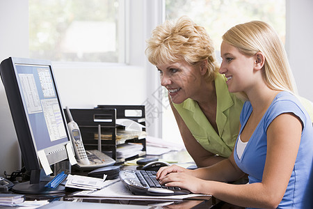 家中办公室的妇女和女孩 带着计算机微笑的电脑技术青年冲浪妈妈商业文书工作两个人青少年女儿图片