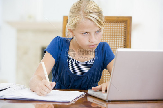 有笔记本电脑的年轻女孩在餐厅做功课图片