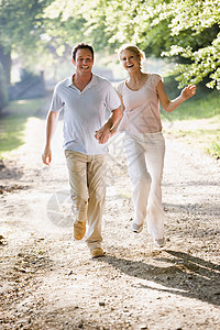 夫妇在户外奔跑 手牵手微笑享受女士小路男人妻子世代公园男性女性两个人图片