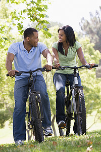一对在户外骑自行车的夫妇微笑着男人丈夫山地踪迹农村世代女性两个人公园骑术图片