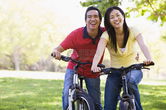 一对在户外骑自行车的夫妇微笑着女子女士享受公园相机踪迹男性两个人女性山地图片