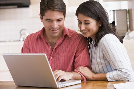 在厨房的夫妇 手持笔记本电脑微笑两个人阅读中年账单技术女士文书丈夫女性预算图片