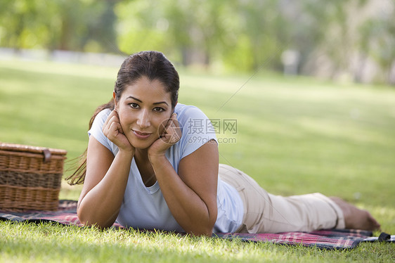 露着野餐篮子微笑躺在公园户外的妇女种族餐垫情绪水平情感成年人毯子女性餐篮闲暇图片