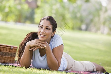 露着野餐篮子微笑躺在公园户外的妇女幸福毯子情绪情感闲暇种族女性餐垫水平餐篮图片