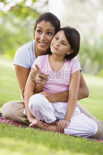 母亲和女儿在户外公园中指着并微笑着妈妈拥抱年龄种族小学女孩女性亲热小学生情绪图片
