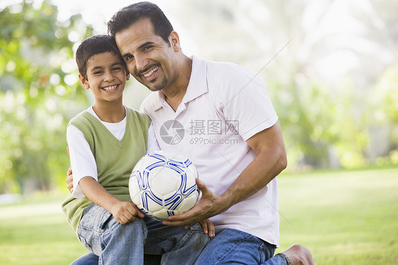 父亲和儿子在户外公园里拥抱和微笑男人小学生孩子们中年幸福情感家长爸爸身份父亲们图片