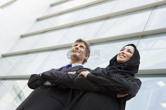 两个商务人士站在户外 建造着微笑的建筑外表合作视角人士伙伴女性商界同事一代会议图片