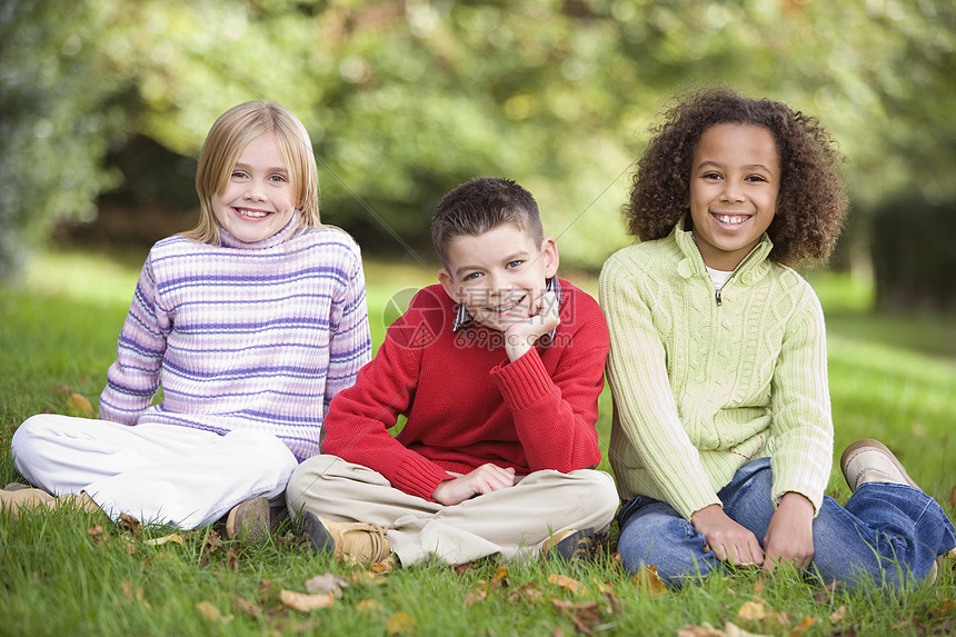 三名儿童坐在户外公园中微笑着笑容的小孩焦距孩子们成年人叶子家庭情感孩子情绪人种途径图片