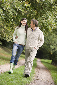 在公园里微笑的路上行走在户外的情侣男性夫妇伙伴幸福丈夫女性亲热外表成年人焦距图片