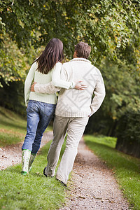 在公园里微笑的路上行走在户外的情侣感情幸福男性伙伴女性情绪亲热夫妻成年中年图片