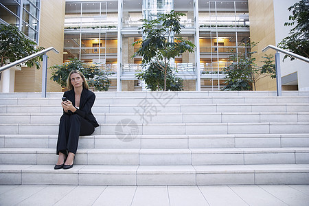 在楼梯上思考的女商务人士中庭手机公司细胞沉思沟通女性商业商务人士图片