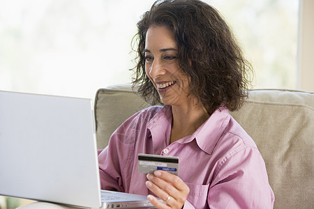 妇女在家里网上购物拉丁电脑商业微笑信用卡家庭金融零售电子商务中年图片