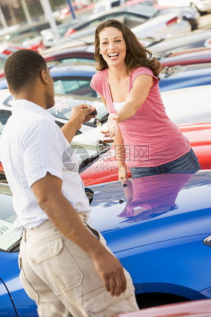 女人拿起新车钥匙女性推销员顾客拉丁两个人成人预算富裕零售经销商图片
