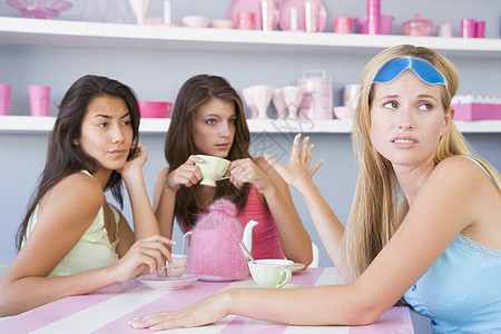 坐在一张桌子上的三个年轻妇女商业着装食物休闲服朋友时间休息咖啡馆黑发头发图片