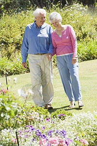 在花园散步的老年夫妇花坛女士享受微笑两个人男人女性祖父老人友谊图片