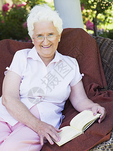 高级妇女阅读书老人女性祖父母相机眼镜老年微笑祖母头发花园图片