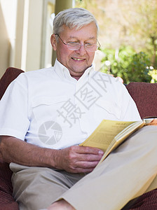 坐在户外的高级妇女坐在椅子上阅读一本书休闲装着装成年人服装老化休闲服休闲成人图片