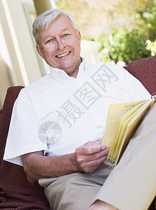 坐在户外的高级妇女坐在椅子上阅读一本书成人休闲服老化服装着装成年人休闲休闲装图片