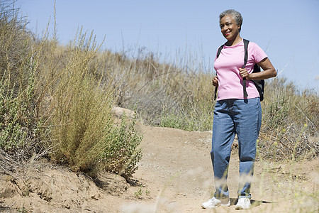 高级女子在散步的足迹上老化成年人背包视角成人图片
