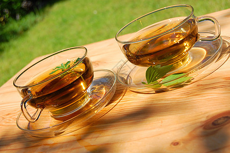 园里的茶杯桌子咖啡店咖啡玻璃饮料餐巾叶子闲暇绿色太阳图片