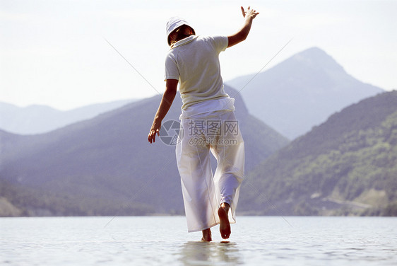 女性户外在风景地点水上行走的妇女外表相机天空人种蓝天成年人爬坡湖泊成人丘陵图片