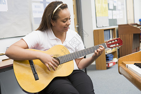 女学生在课堂上学习吉他班级原声吉他手教室黑发图片