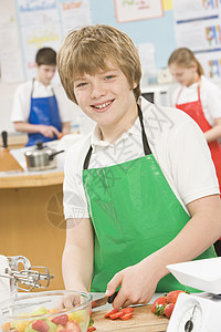 在烹饪班上切浆果的男生学生孩子们男孩们教室围裙班级孩子家电课堂人物头发图片