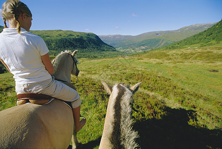 妇女户外在风景地点骑马外表爬坡马匹蓝天天空成人大自然成年人人种女性图片