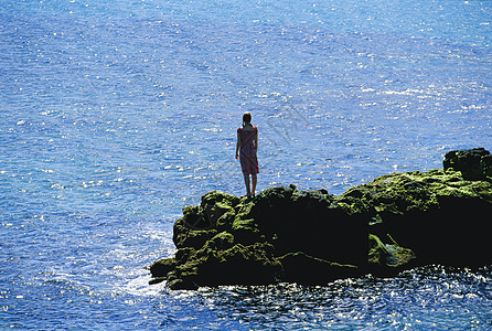 露天妇女站在海边大岩石上成人女性成年人人种相机外表和平海洋海岸图片