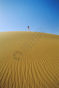 妇女户外在沙漠中行走(远处)图片