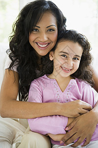 母亲和女儿在起居室微笑(高键)图片