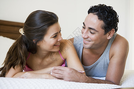 夫妻在卧室的床上放松微笑选择性焦点成人特写男朋友视角成年人感情人种镜头情侣外表图片