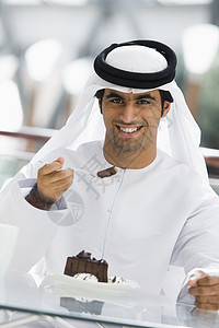 餐厅里的男人吃甜点和微笑(选择性焦点)背景图片