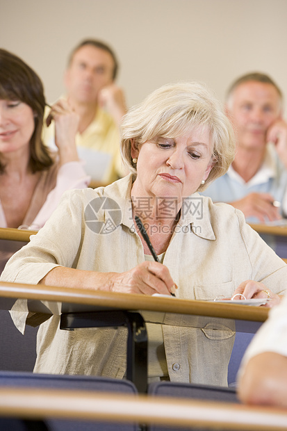 坐在成人课堂上与背景学生一起作笔记选择性重点的女教师服装休闲成年人同学们服饰班级一代同学休闲服教室图片