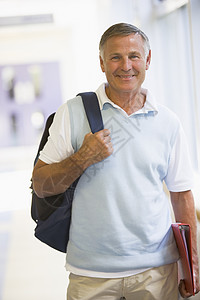 男人用背包(高键)站在走廊上图片