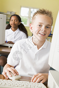 学生在计算机终端打字 背景是学生 选择性焦点男孩们班级中心电脑孩子们人物课程男生视角同学图片