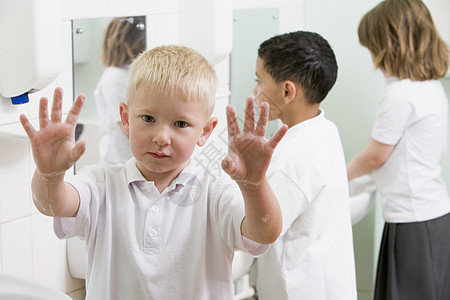 在洗手间用一根举着肥皂手的洗手池的学生选择性重点同学镜子清洁度男孩们水槽正装浴室孩子小学种族图片