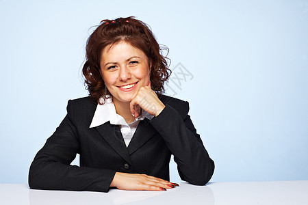 一位在蓝背景下微笑的快乐商业女性形象图片