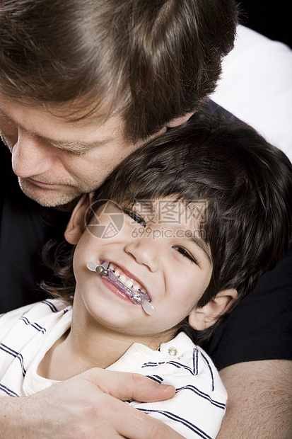 父亲与儿子同在男生微笑儿童混血家庭拥抱男人牙套残障纽带图片